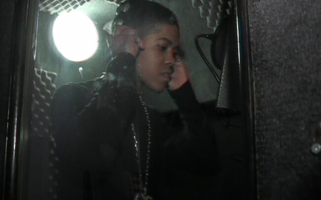 Young Chipmunk in a sound booth recording and holding his headphones
